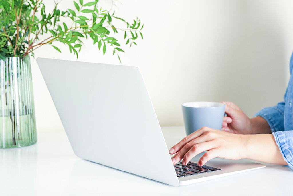 Working on laptop with a coffee in hand